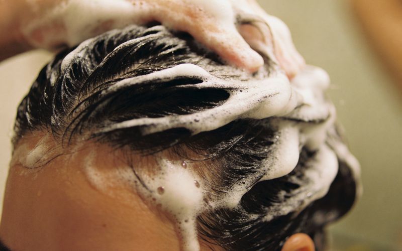 Femme qui se fait un shampoing